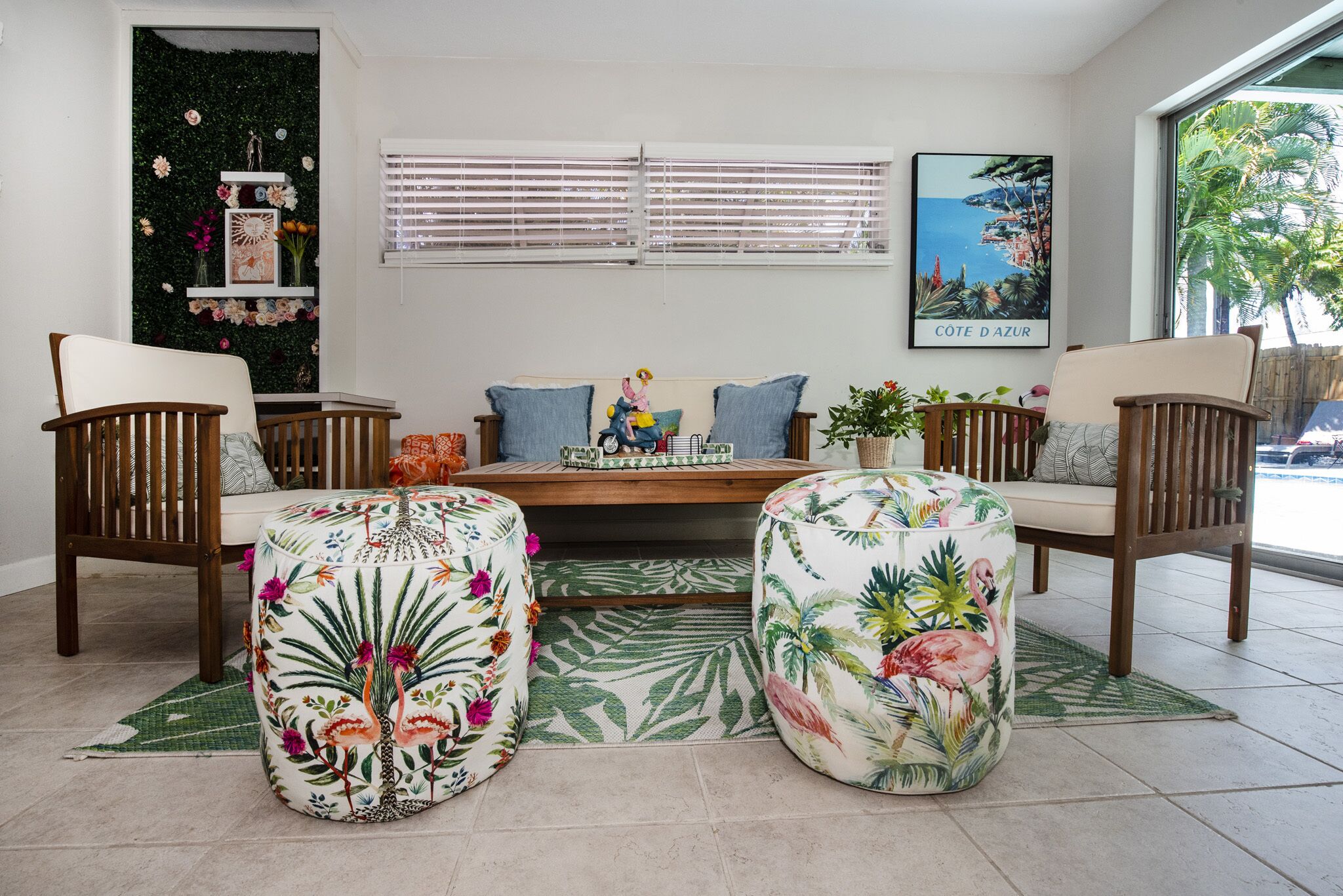 A living room with a sofa, two wooden chairs, a coffee table, and a tropical-themed rug.