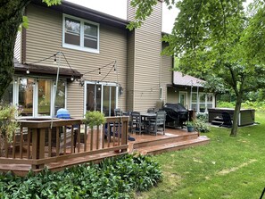A house with a deck, outdoor furniture, and a barbecue area.