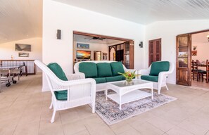 A room with a white wicker sofa set, a coffee table, and a patterned rug. - Ultra-private villa on the fairway at world-famous Tryall Golf Club. (Sandy Bay)
