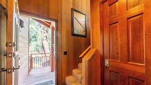 Un interior de madera con una escalera que lleva a un balcón.