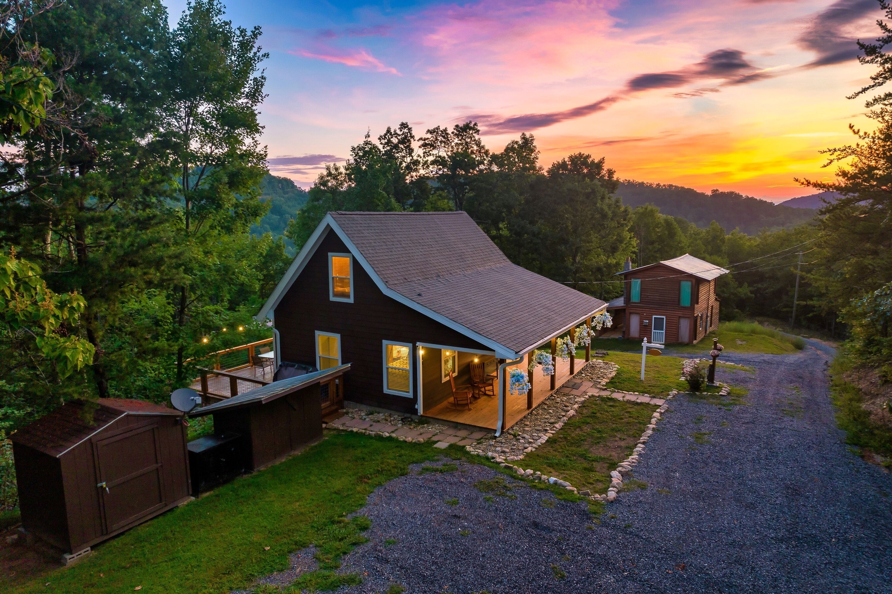 A two-story house with a porch, a garage, and a gravel driveway.
