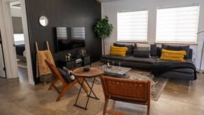 Ein stilvolles Wohnzimmer mit Sofa, Couchtisch und Fernseher.
