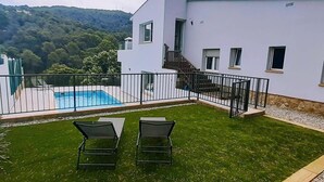 A modern house with a swimming pool, a grassy lawn, and a staircase leading to a balcony. - Villa Casa Nuestra with Private Pool, Garden & Wi-Fi (Begur)