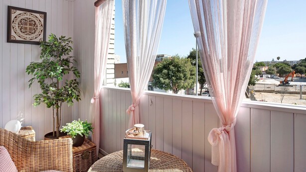A balcony with wicker furniture, potted plants, and a view of the cityscape. - Holiday Apartment "El Refugio" with Wi-Fi & Terrace (Jerez de la Frontera)