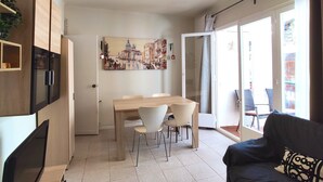 Un espace de vie moderne comprenant un coin repas, un canapé et une grande fenêtre.