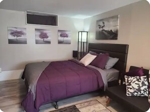 A bedroom with a bed, a bedside table, a floor lamp, and wall art. - The cozy nook in waterloo (Waterloo)