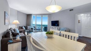 Un salon moderne avec une table à manger, des canapés et un téléviseur.