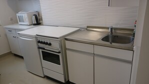 A kitchen with white appliances, including a microwave, toaster, and oven. - Penthaus Am Köpcke (Hannover)