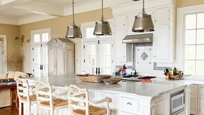 A spacious kitchen with a large island, white cabinetry, and hanging pendant lights. - Chef’s Kitchen, Fast Wi-Fi (Hillsdale)