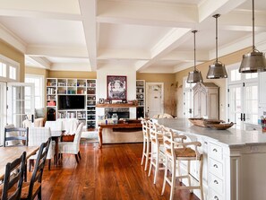 A spacious kitchen with a central island, wooden flooring, and white cabinetry. - Chef’s Kitchen, Fast Wi-Fi (Hillsdale)