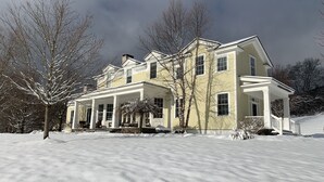 A large, two-story house with a covered porch and a snow-covered lawn. - Chef’s Kitchen, Fast Wi-Fi (Hillsdale)