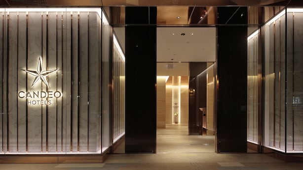 The entrance to Candeo Hotels with a modern design, featuring a star logo and vertical light panels. - Candeo Hotels Kumamoto Shinshigai (Kumamoto)