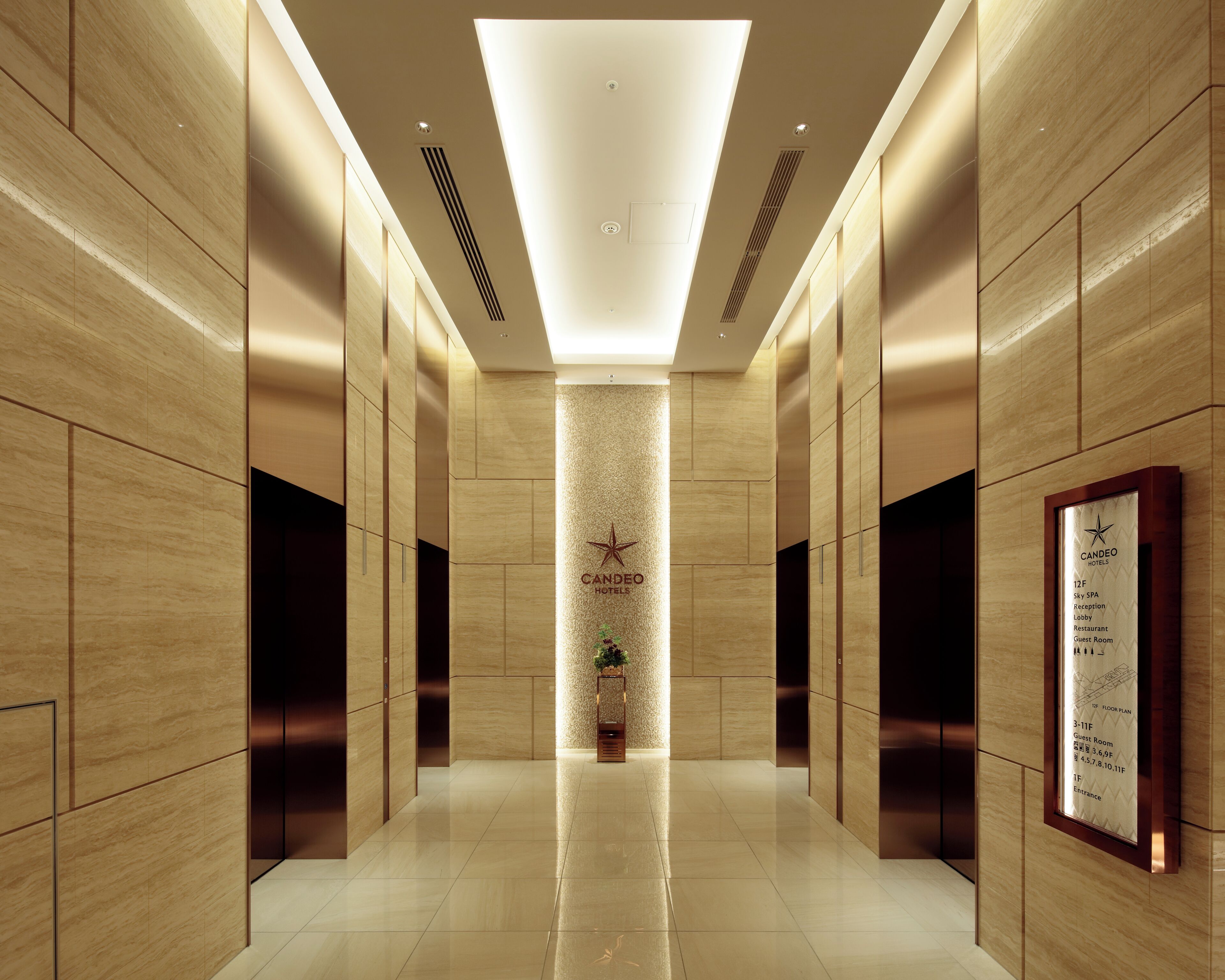 A hotel corridor with a star logo, a reception desk, and a floor plan sign.