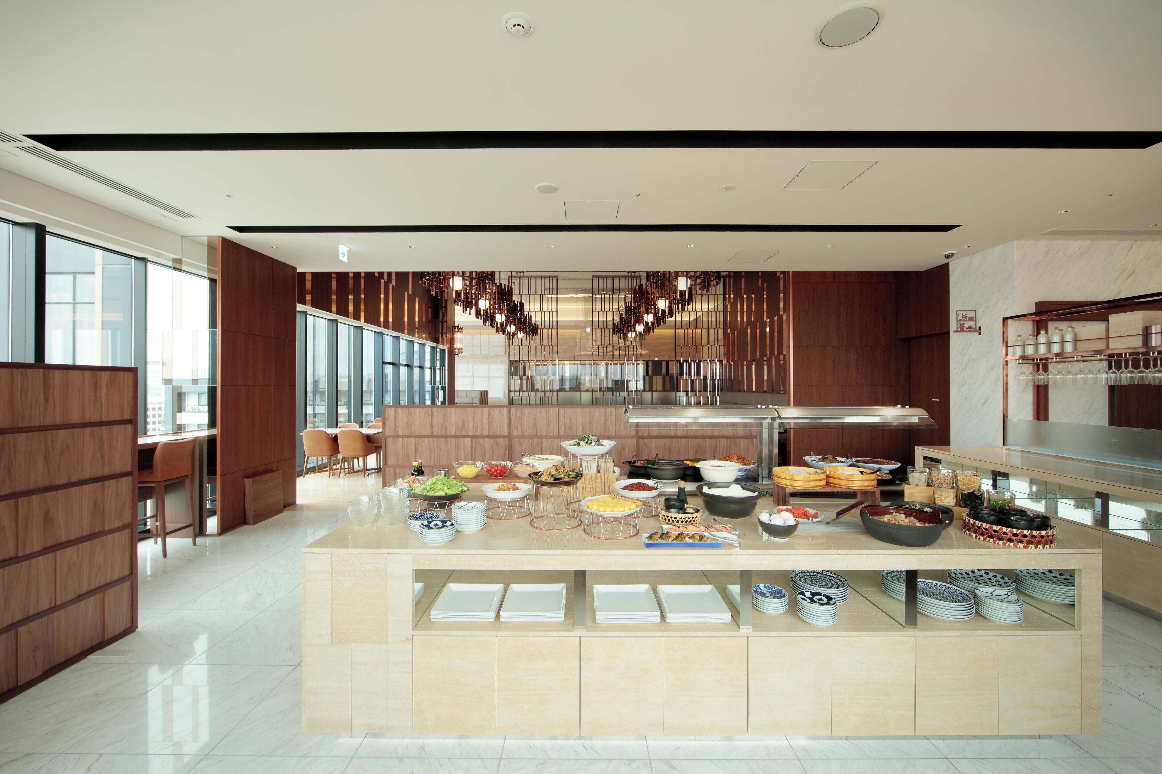 A modern kitchen with a buffet setup, wooden paneling, and a large island with various food items.