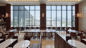 A modern dining area with large windows, wooden tables, and contemporary lighting fixtures. - Candeo Hotels Kumamoto Shinshigai (Kumamoto)