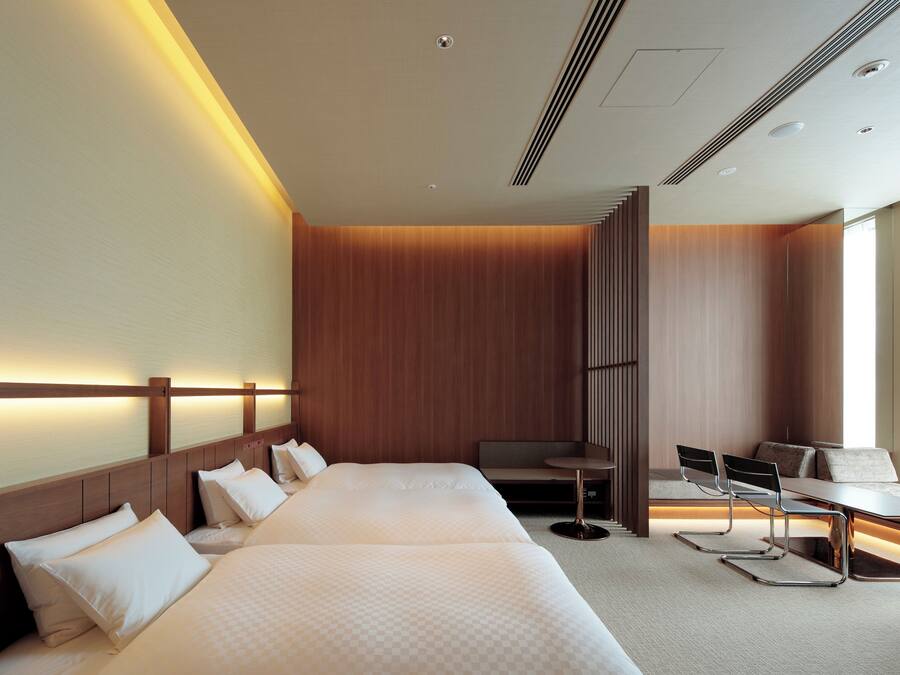A hotel room with a large bed, a desk, and a chair.