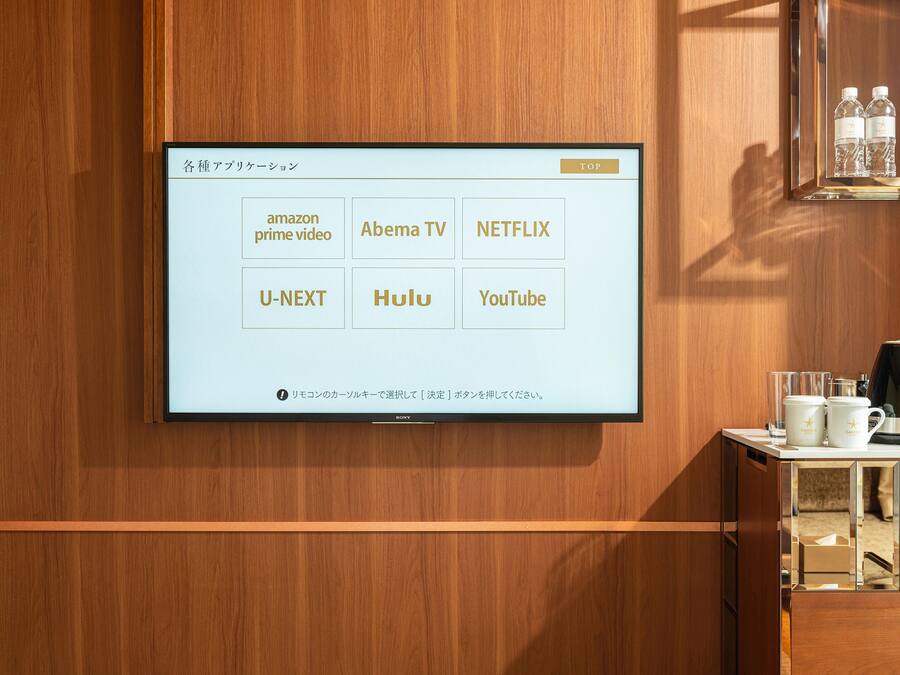 A wall-mounted TV displaying a selection of streaming services.