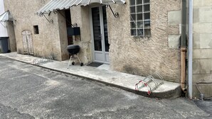 A building with a stone facade, a metal awning, a door, and a window.