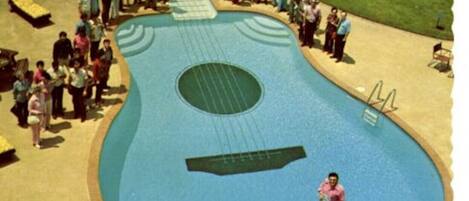 A pool shaped like a guitar with a person standing in the center.