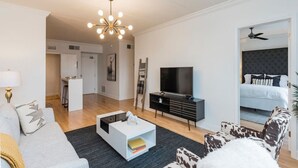 Een moderne woonkamer met een bank, een salontafel, een televisie en een open haard.
