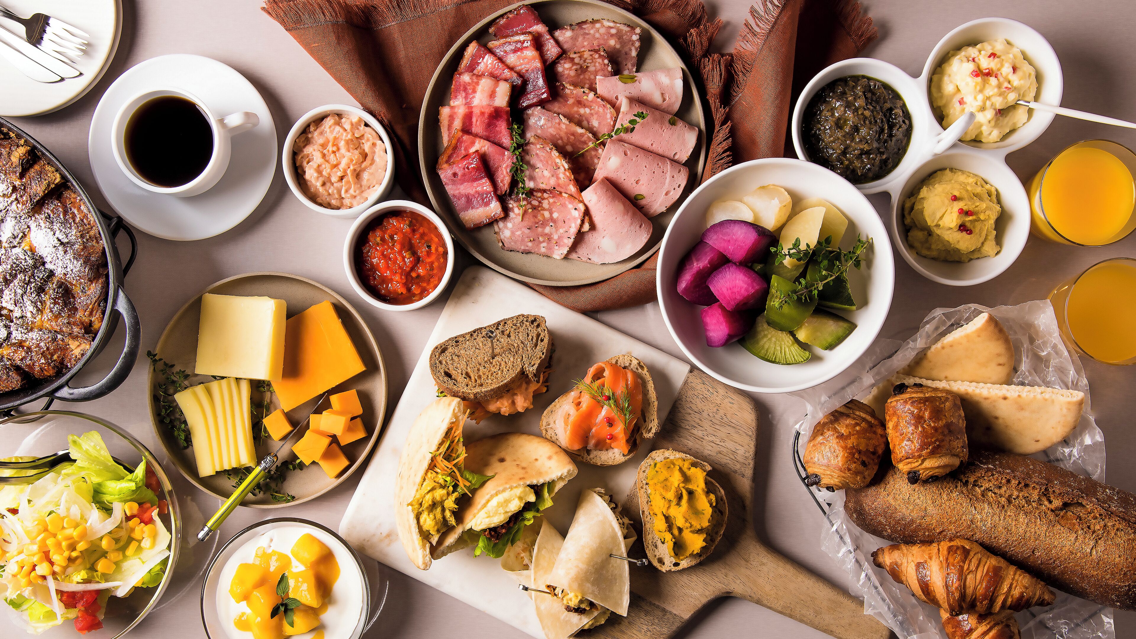 A variety of food items including cheese, bread, and sandwiches, arranged on a table.