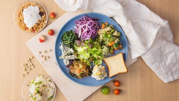 A meal with various dishes on a blue plate, including salad, bread, and a bowl of soup.