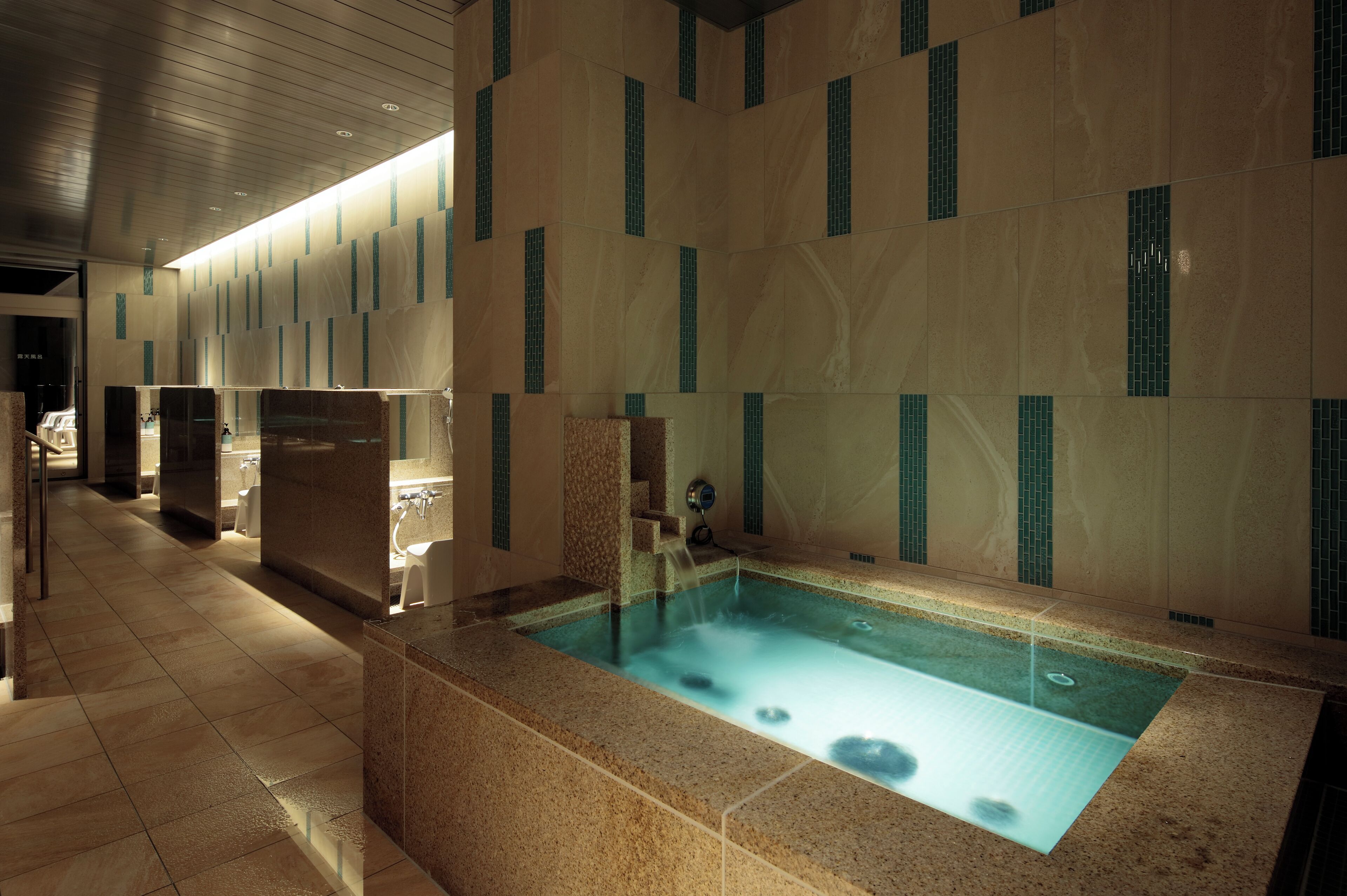 A modern spa area with a large hot tub, tiled walls, and a clean, well-lit interior.