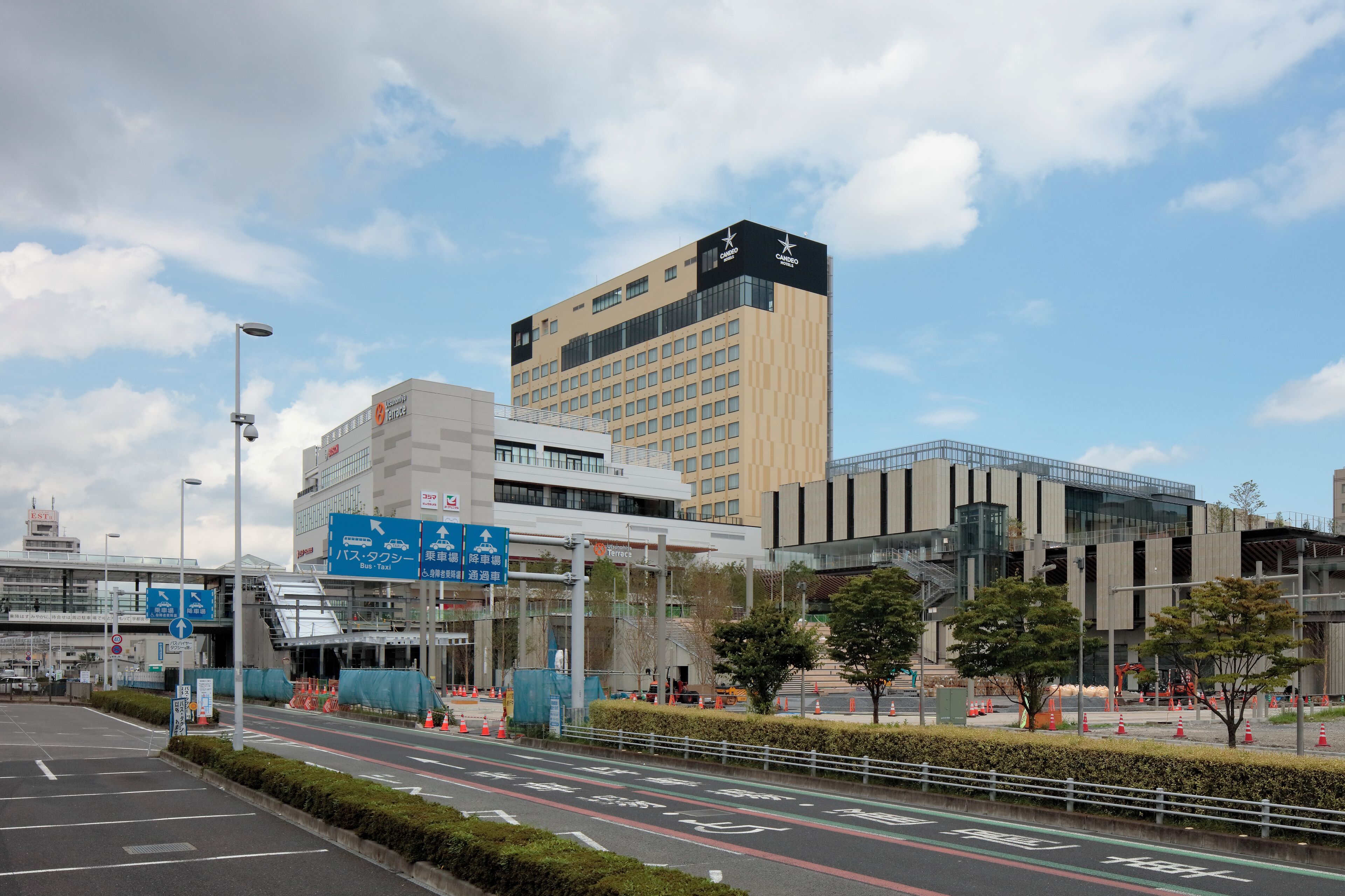 Un bâtiment moderne, doté d’une enseigne bien visible indiquant la présence d’un hôtel et d’une gare routière.