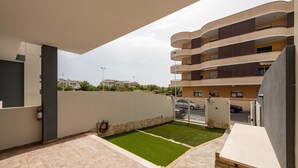 A residential building with a balcony, a small lawn, and a stone wall. - Holiday Home Casa Mattia with Terraces, Garden & Wi-Fi (Quartu Sant'Elena)