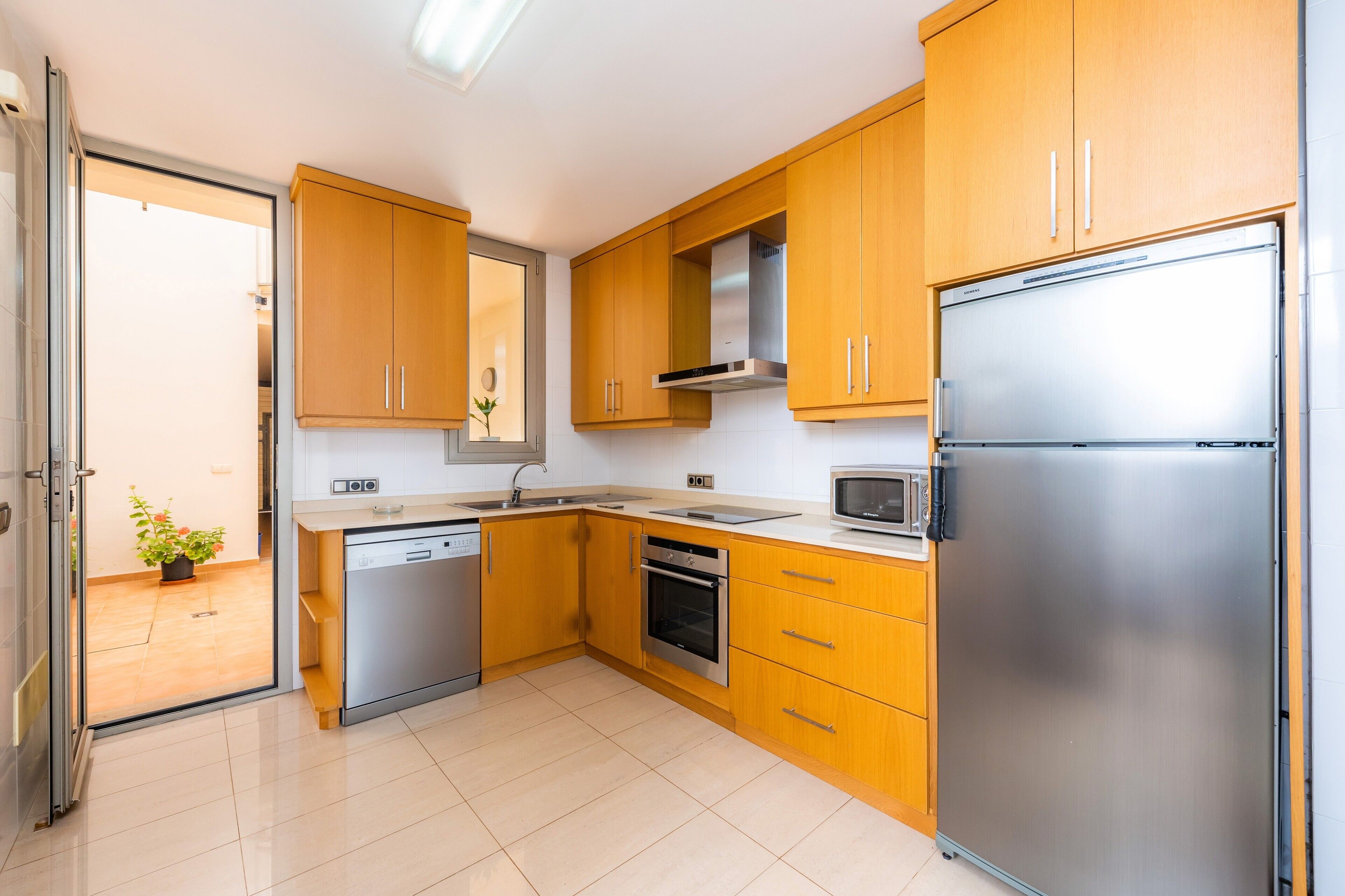 A modern kitchen with wooden cabinets, stainless steel appliances, and a dishwasher.