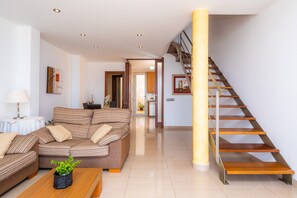 Una sala de estar moderna con un sofá, una mesa de centro y una escalera.