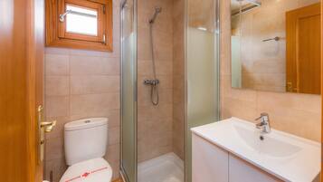 Un baño con inodoro, ducha y lavamanos.