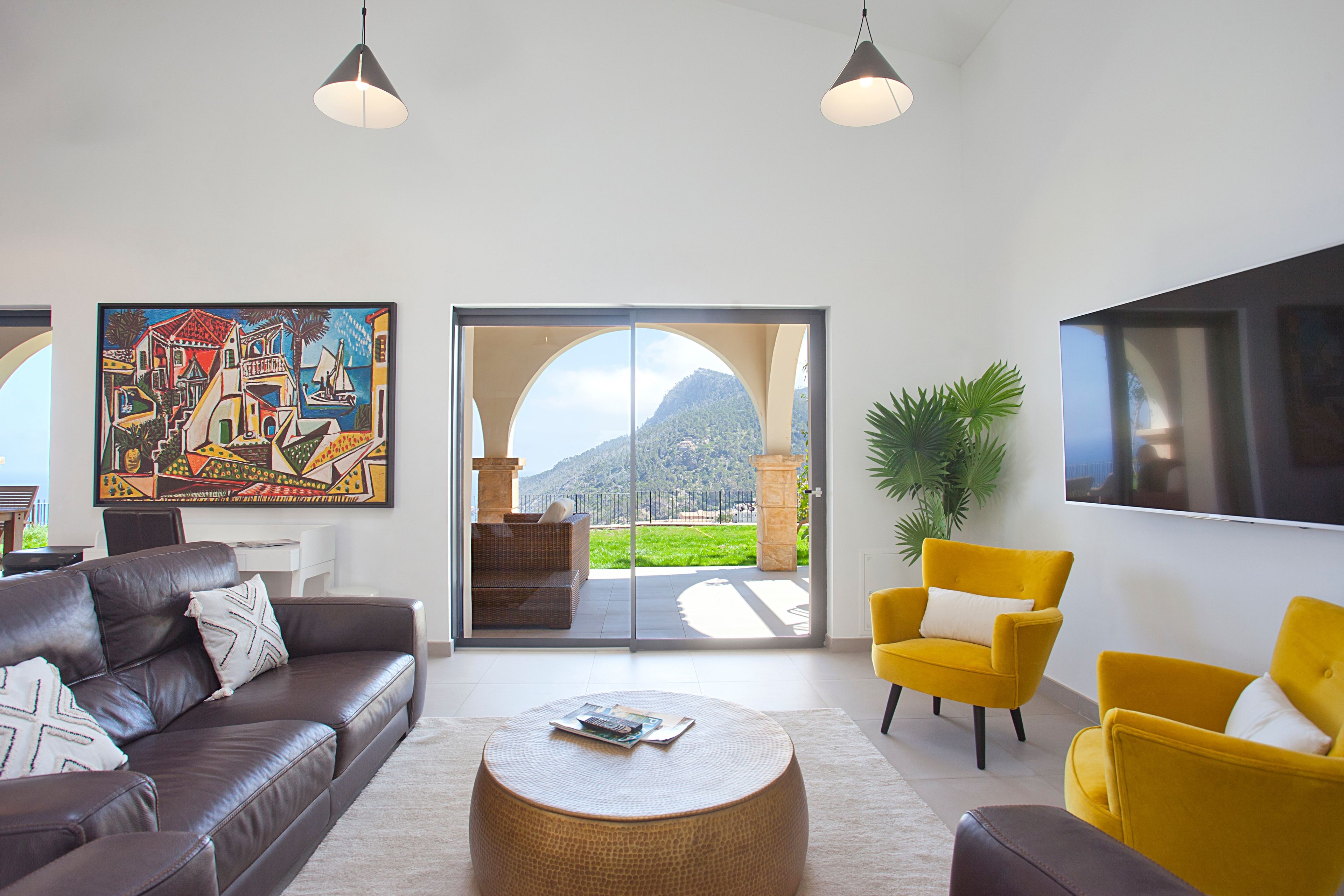 Una sala de estar moderna con un sofá, sillones, una mesa de centro y un cuadro grande.