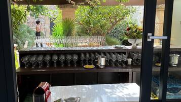 Un área de bar con vistas a un jardín a través de una ventana.