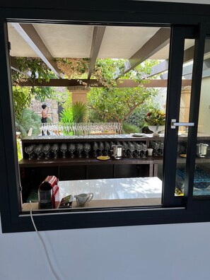 A bar area with a view of a garden through a window.