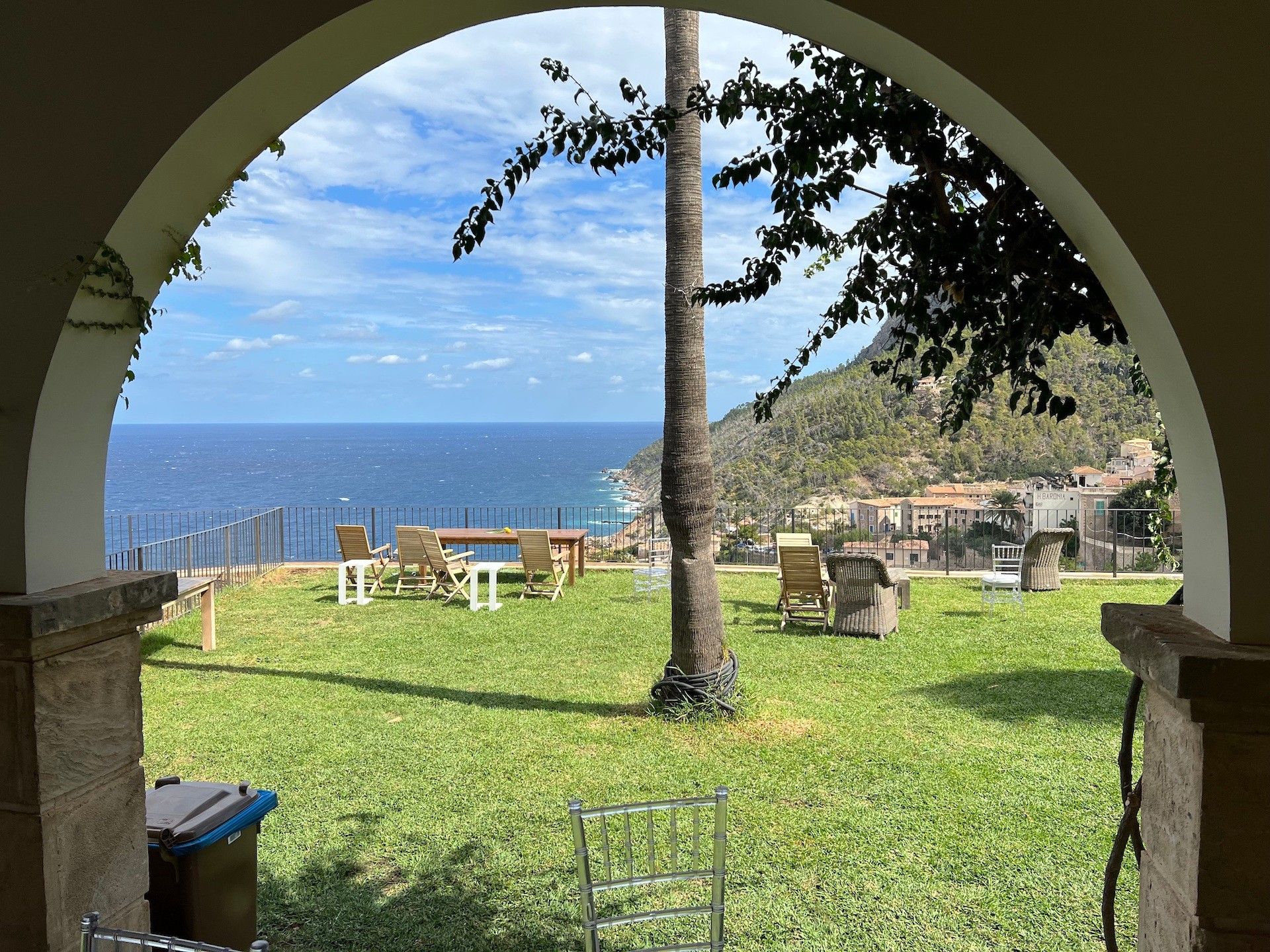 Un espacio de estar al aire libre con vistas al mar y una colina.