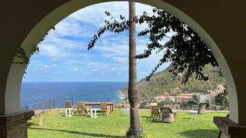 Un espacio de estar al aire libre con vistas al mar y una colina.