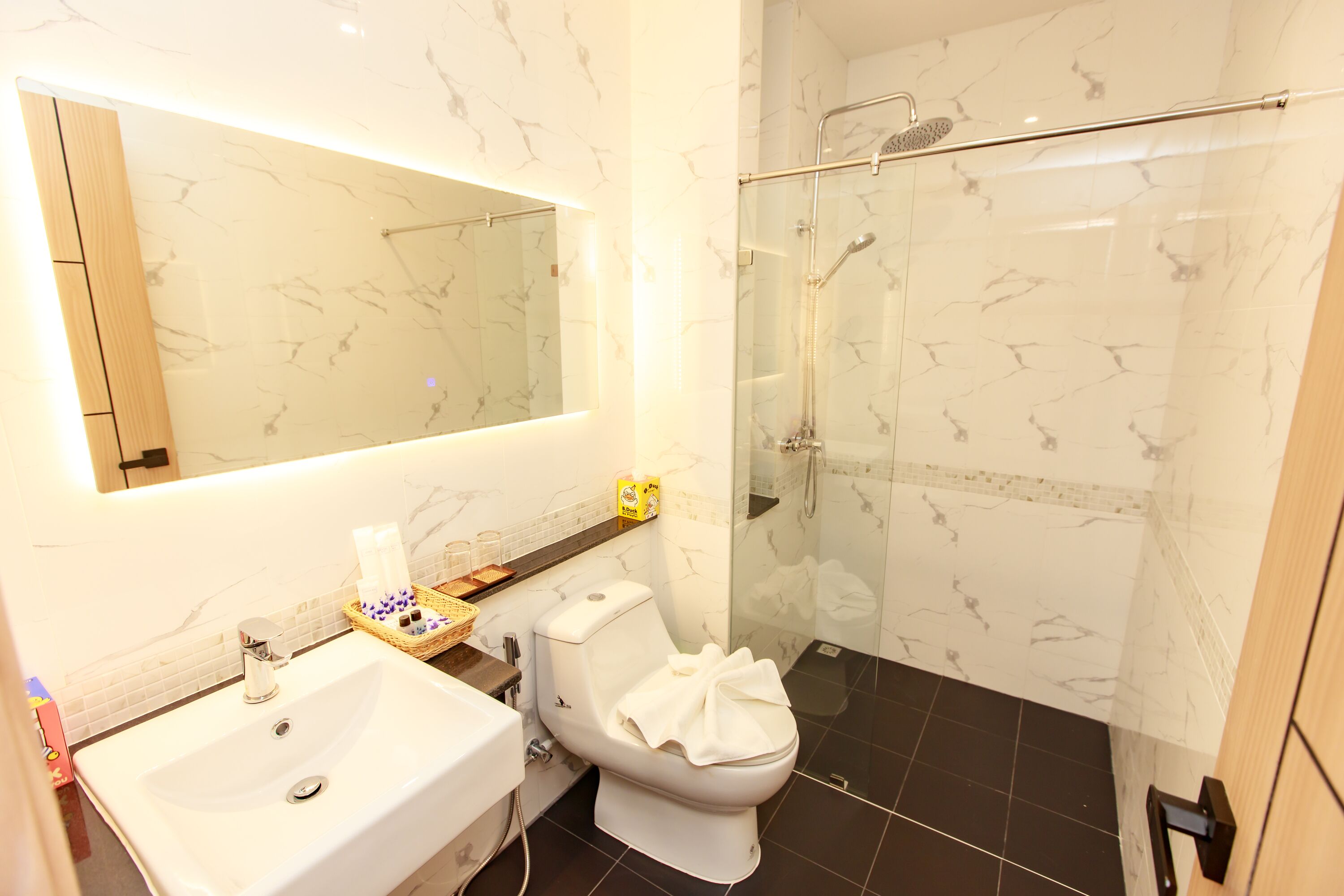 A bathroom with a white sink, a toilet, and a glass-enclosed shower.