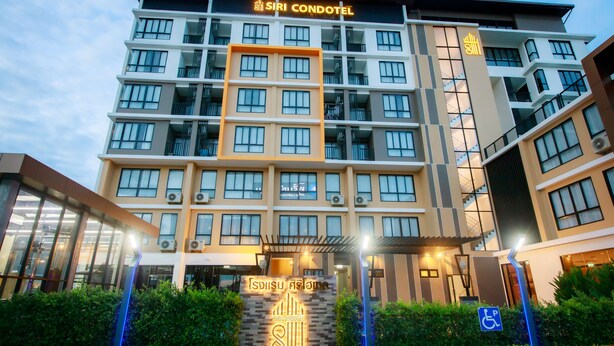 A multi-story hotel with a prominent entrance, a sign indicating a disability access point, and a well-lit facade. - Siri Hotel Lumphun (Lamphun)