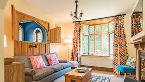 A cozy living room with a sofa, a wooden coffee table, and a patterned rug. - The Gate House - sleeps 4 guests  in 2 bedrooms (Folkestone)