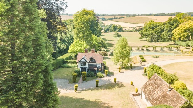 A traditional Tudor-style house with a well-maintained garden, surrounded by trees and open fields. - The Gate House - sleeps 4 guests  in 2 bedrooms (Folkestone)