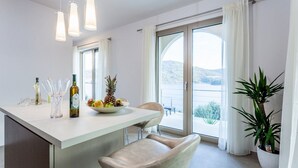 Uma cozinha moderna com uma ilha central, um espaço de refeições com uma cadeira e uma grande janela com vista para o exterior.