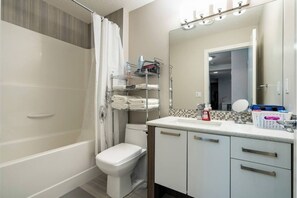 Combined shower/tub, hair dryer, towels, soap - The Premier Suite | 321Mbps WiFi | Perfect Stays (Airdrie)