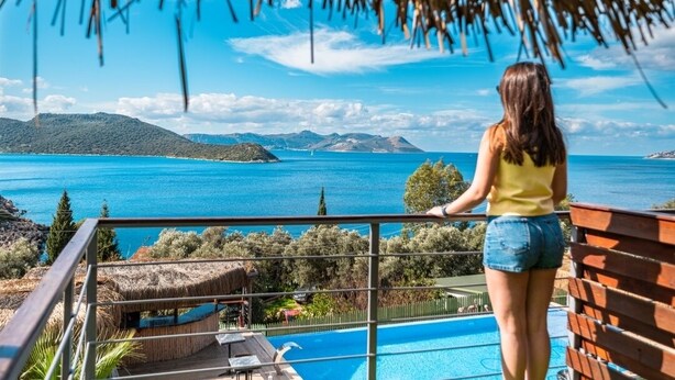A balcony with a view of a swimming pool and the sea. - The Luxury Shelters (Kas)