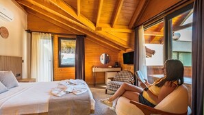 A cozy room with a bed, a chair, a desk, and a TV. - The Luxury Shelters (Kas)