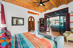 A hotel room with a large bed, a wardrobe, a mirror, and a view of the outside. - Villa Iguana (Villas del Corazon) (Sayulita)