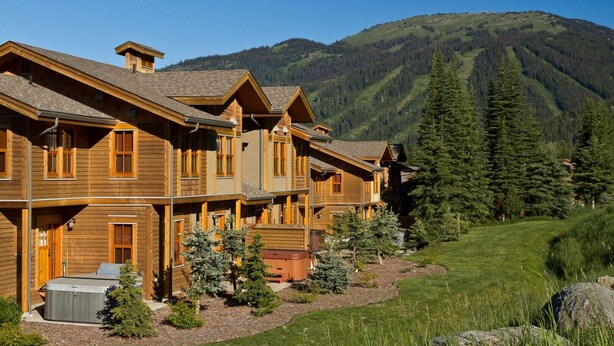 Una cabaña de madera con varias habitaciones, un jacuzzi y vistas a una cordillera.