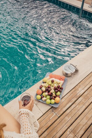A wooden deck by a pool with a fruit platter and a drink. - Minimalist Sapanca (Sapanca)