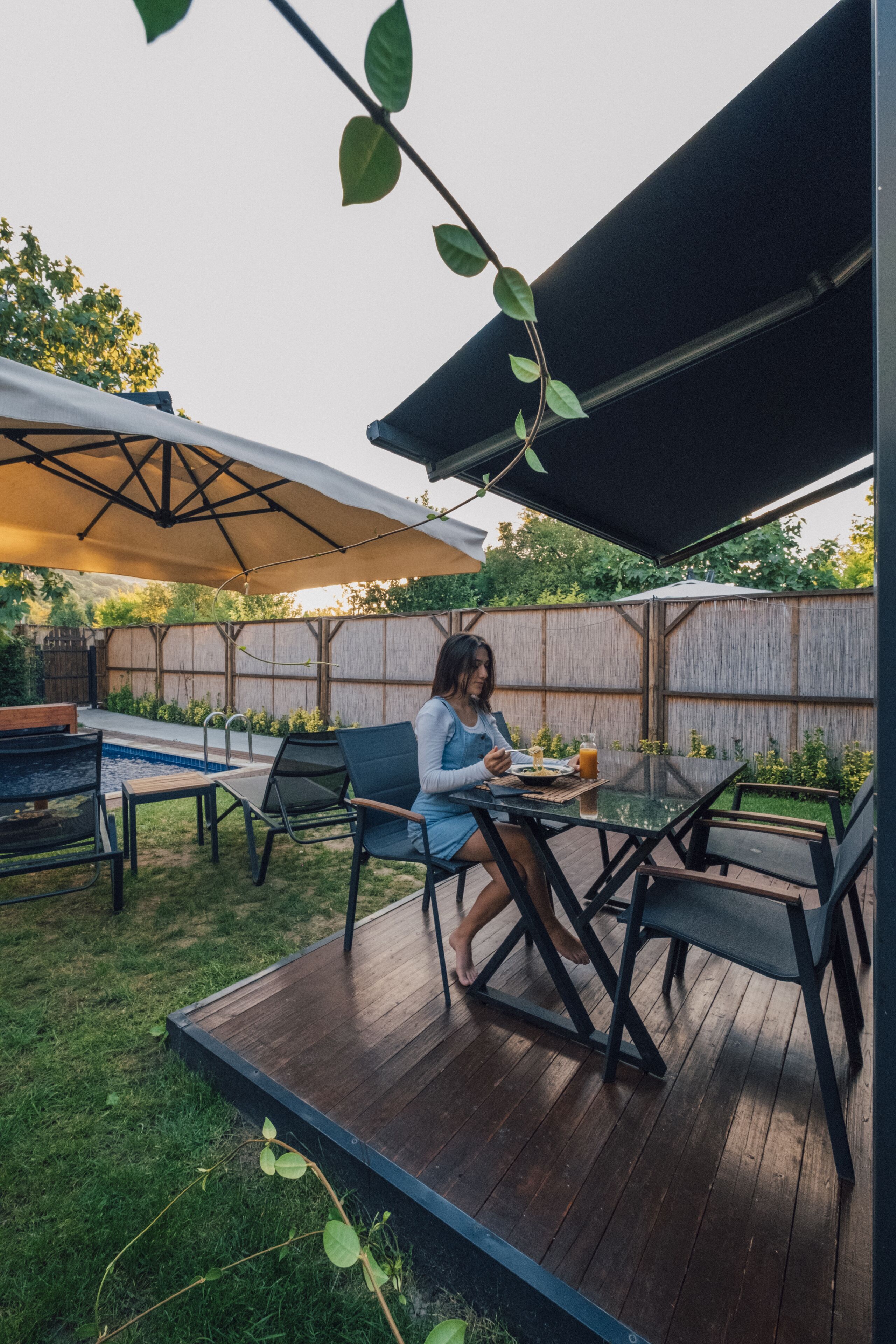 Eine Terrasse mit Tisch und Stühlen, ein Schwimmbad und eine Holzterrasse.