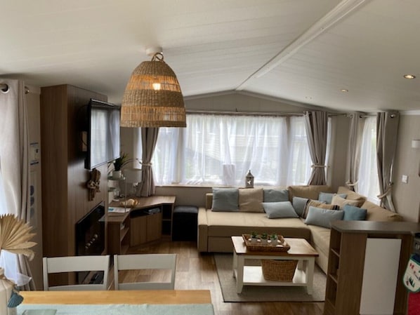 A cozy living room with a sofa, a dining table, and a kitchen area.